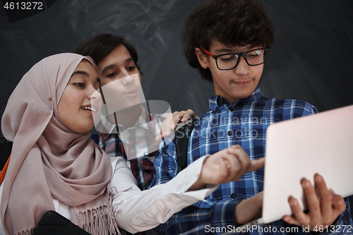 Image of Arab teenagers group working on laptop and tablet computer