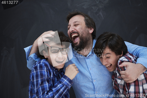 Image of happy father hugging sons