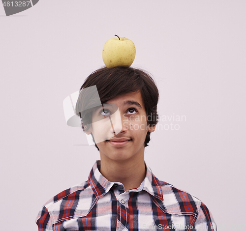 Image of portrait of a young  teen boy with an apple on his head