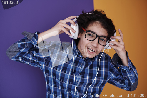 Image of Teenage Boy Wearing Headphones And Listening To Music