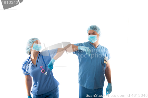 Image of nurses in scrubs elbow bump instead of shaking hands during COVI