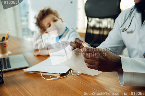 Image of Little caucasian boy as a doctor consulting for patient, working in cabinet, close up