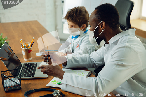 Image of Little caucasian boy as a doctor consulting for patient, working in cabinet, close up