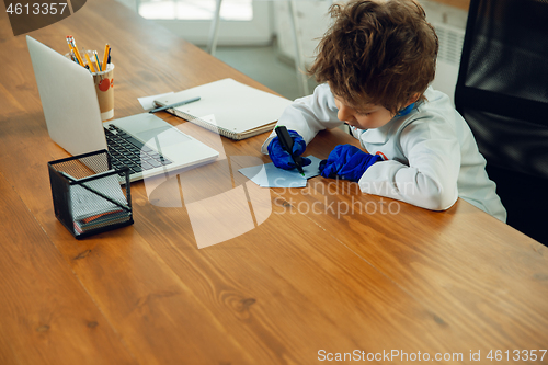 Image of Little caucasian boy as a doctor consulting for patient, working in cabinet, close up