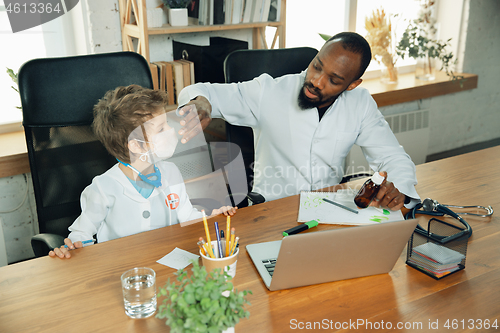 Image of Little caucasian boy as a doctor consulting for patient, working in cabinet, close up