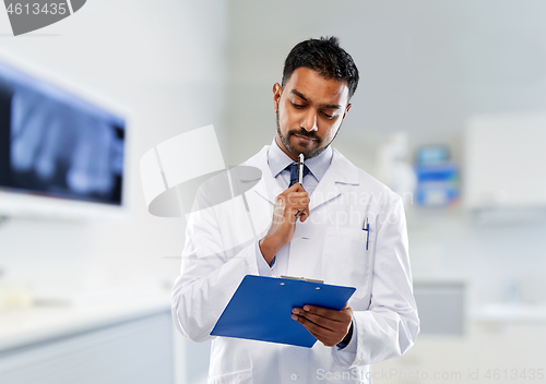 Image of male dentist with clipboard at dental clinic