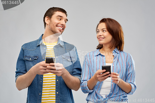 Image of happy couple with smartphones talking