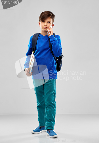 Image of student boy with school bag calling on smartphone