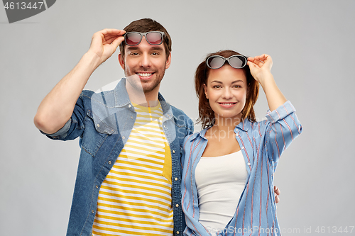 Image of happy couple in sunglasses over grey background