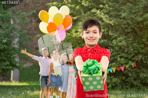 Image of boy with gift box at birthday party in summer park