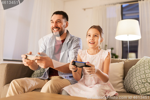 Image of father and daughter playing video game at home