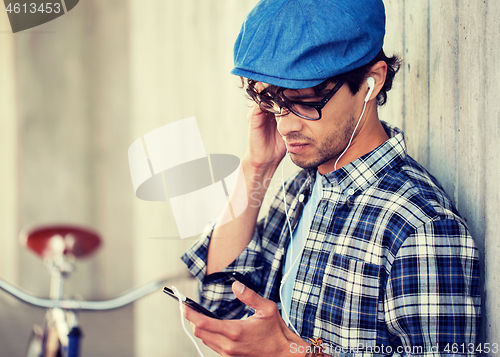 Image of hipster man with earphones, smartphone and bike