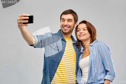 Image of happy couple taking selfie by smartphone