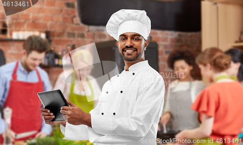 Image of male indian chef with tablet pc at cooking class