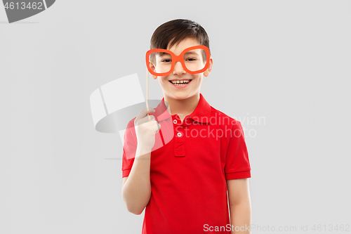 Image of smiling boy in red t-shirt with big paper glasses