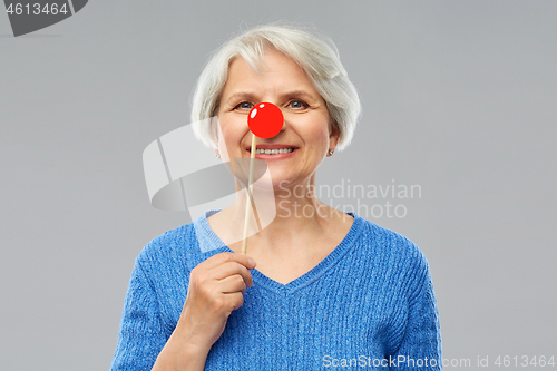 Image of smiling senior woman with red clown nose