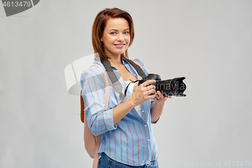 Image of happy tourist woman with backpack and camera
