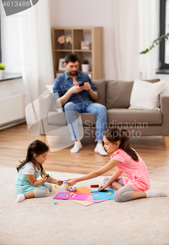 Image of happy sisters doing arts and crafts at home