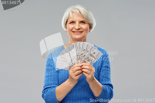 Image of senior woman with hundred dollar money banknotes