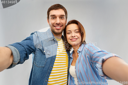 Image of happy couple taking selfie over grey background