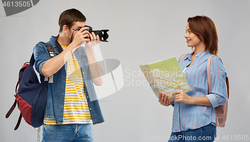 Image of happy couple of tourists with backpacks and camera