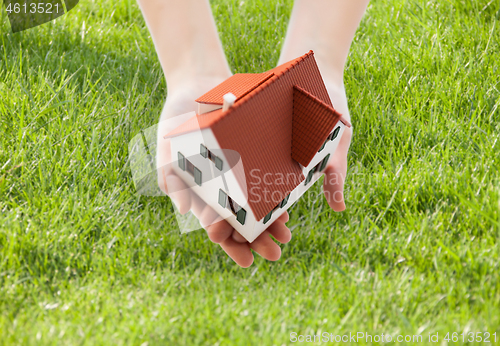 Image of close up of hands holding house or home model