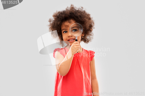 Image of african girl looking through magnifying glass