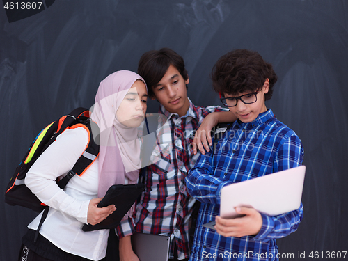 Image of Arab teenagers group working on laptop and tablet computer