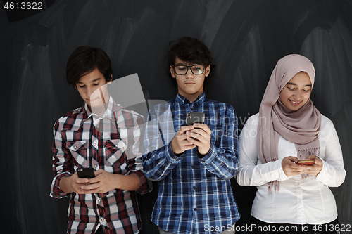 Image of arab teenagers group using smart phones for social media network