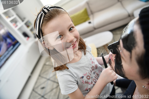 Image of mother and daughter at home making facial mask beauty treatment