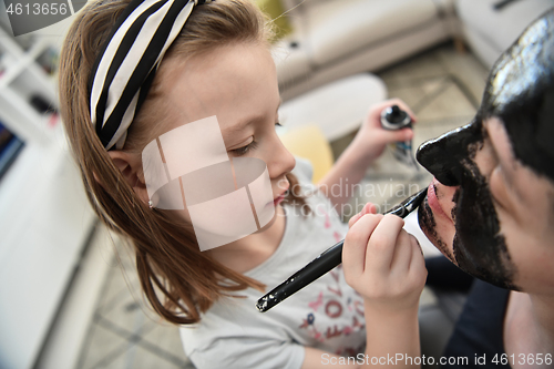 Image of mother and daughter at home making facial mask beauty treatment