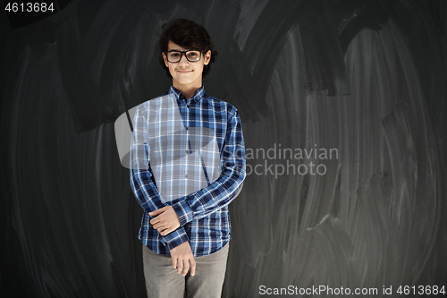 Image of portrait  of smart looking arab teenager with glasses against bl