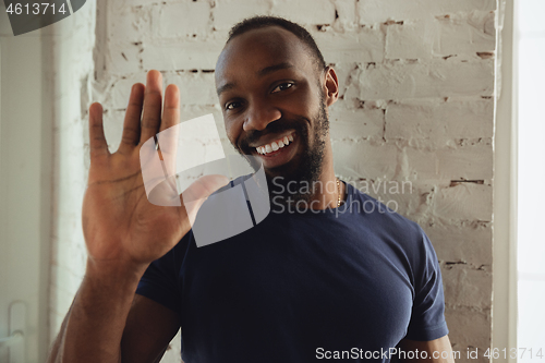 Image of African-american musician isolared on white brick wall background, cheerful and happy