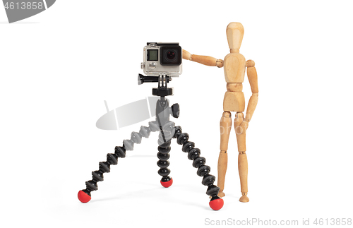 Image of Wooden dummy standing trying to make a video or photo