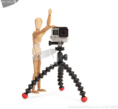 Image of Wooden dummy standing trying to make a video or photo