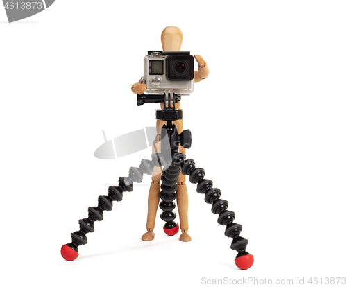 Image of Wooden dummy standing trying to make a video or photo