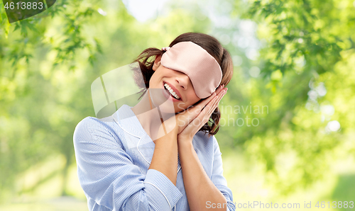 Image of happy young woman in pajama and eye sleeping mask