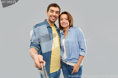 Image of happy couple taking picture by selfie stick