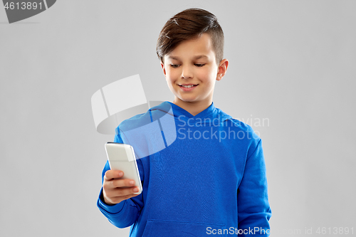 Image of smiling boy in blue hoodie using smartphone