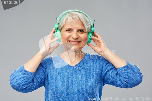 Image of senior woman in headphones listening to music