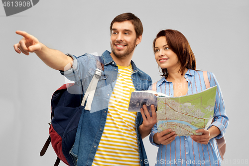 Image of happy couple of tourists with city guide and map