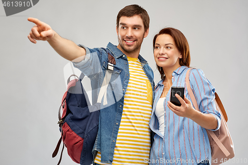 Image of happy couple of tourists with smartphone