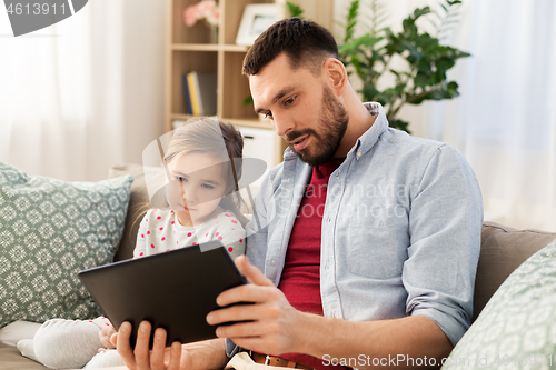 Image of father and daughter with tablet computer at home