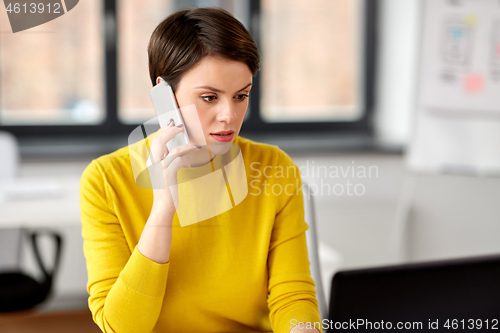 Image of businesswoman calling on smartphone at office