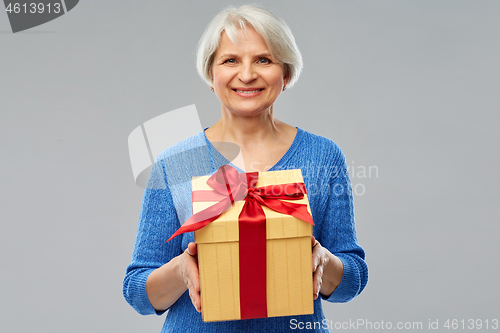 Image of happy smiling senior woman with gift box