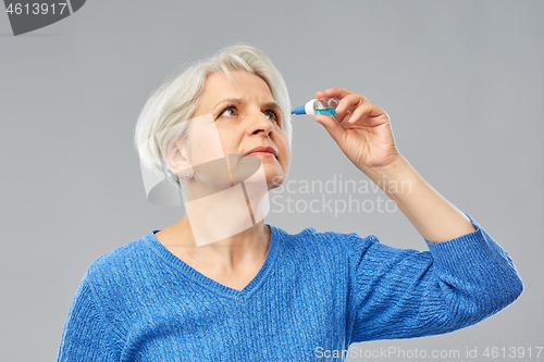 Image of senior woman with dry eye syndrome using drops