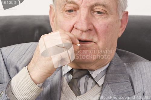 Image of Senior man taking medication