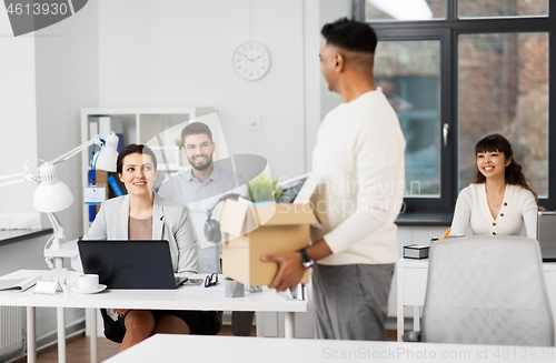 Image of office workers looking at colleague quitting job