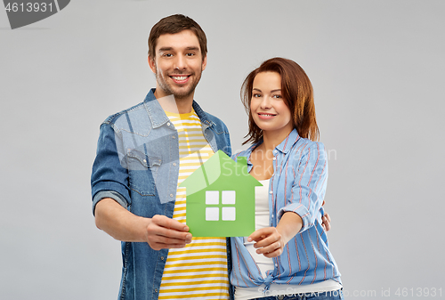 Image of smiling couple holding green paper house