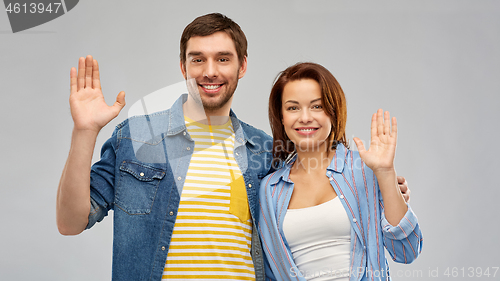 Image of happy couple waving hands